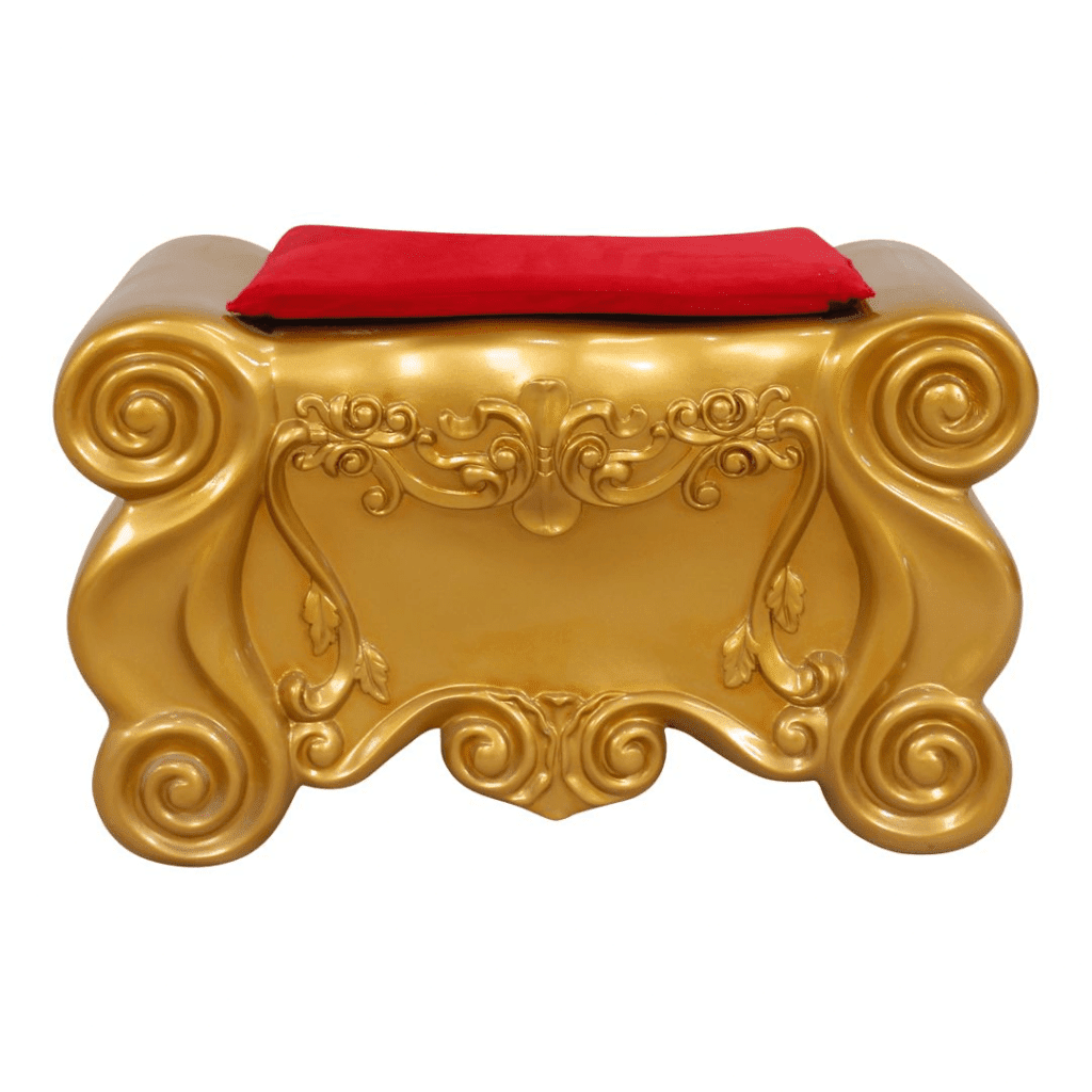 A gold footrest with a red velvet cushion.