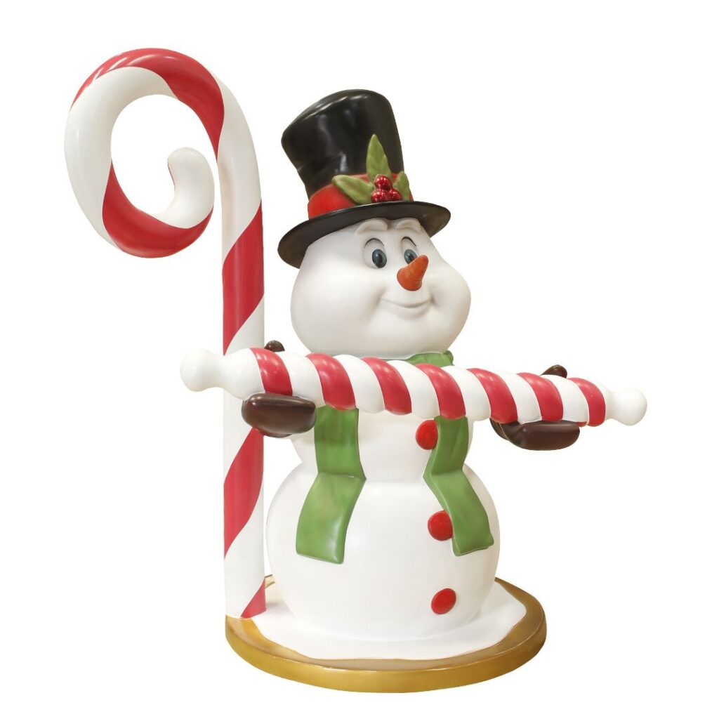 A figure of a snowman with a candy stick, standing in front of a large candy cane.