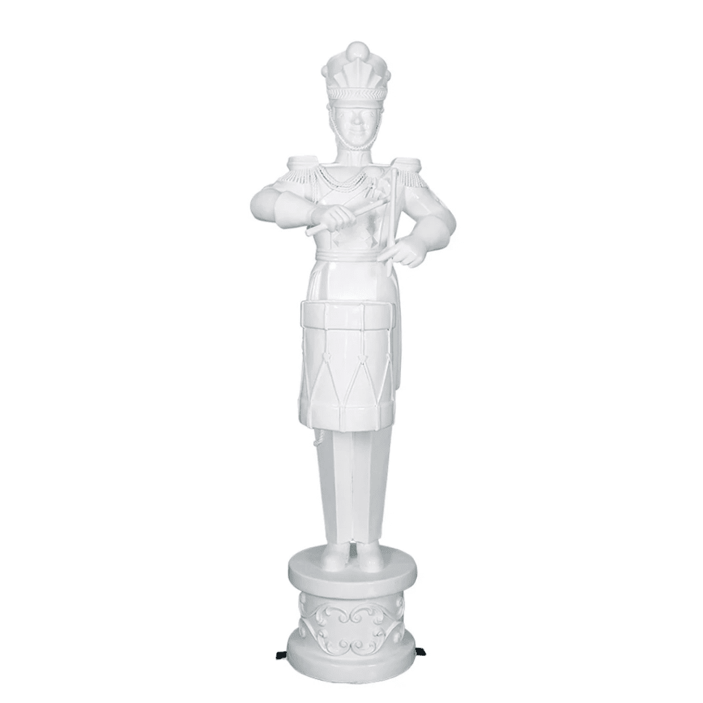 A white toy soldier on a decorative base, playing the drum.