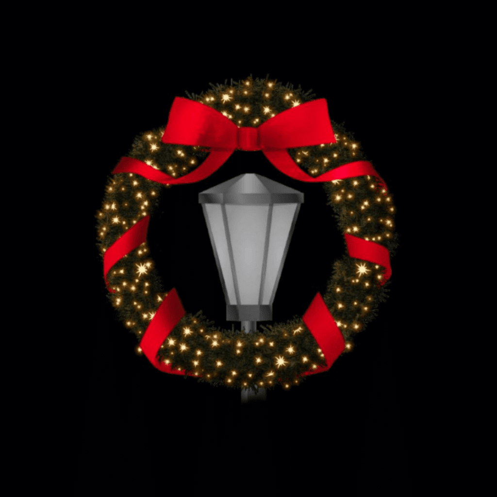 A lamp post with a Christmas wreath around the top.