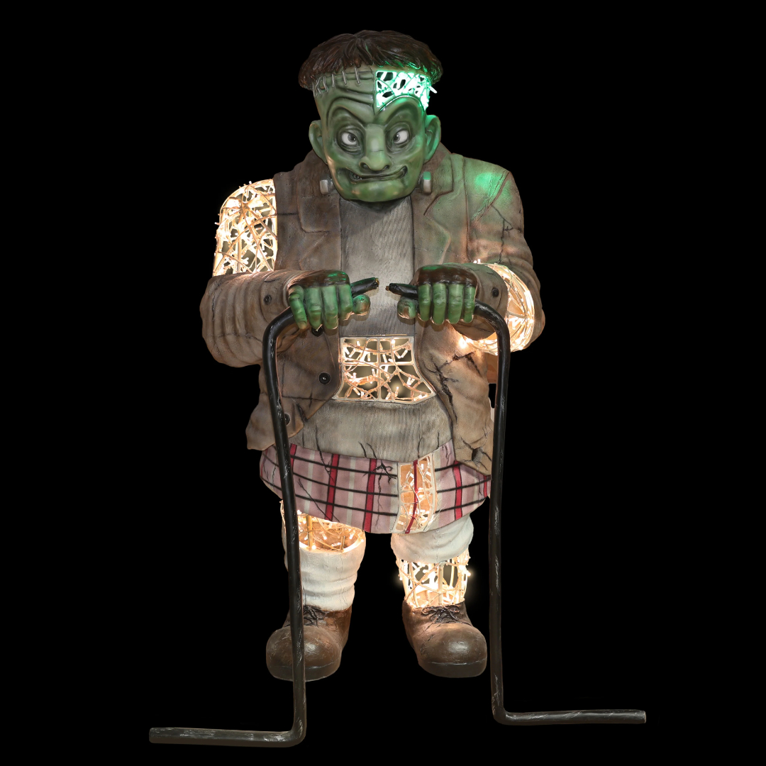 A large Frankenstein's monster statue made from a metal frame, fiberglass accents, and mini LED Christmas lights, connecting two cables with exposed wires.