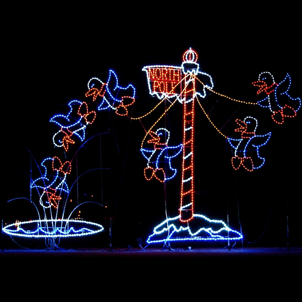 A lighted Christmas silhouette of a penguin swinging from the North Pole sign, and jumping off into water made of lights.