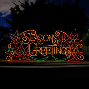 A lighted Christmas silhouette of the words season's greetings in a script type and surrounded by poinsettias made of lights.