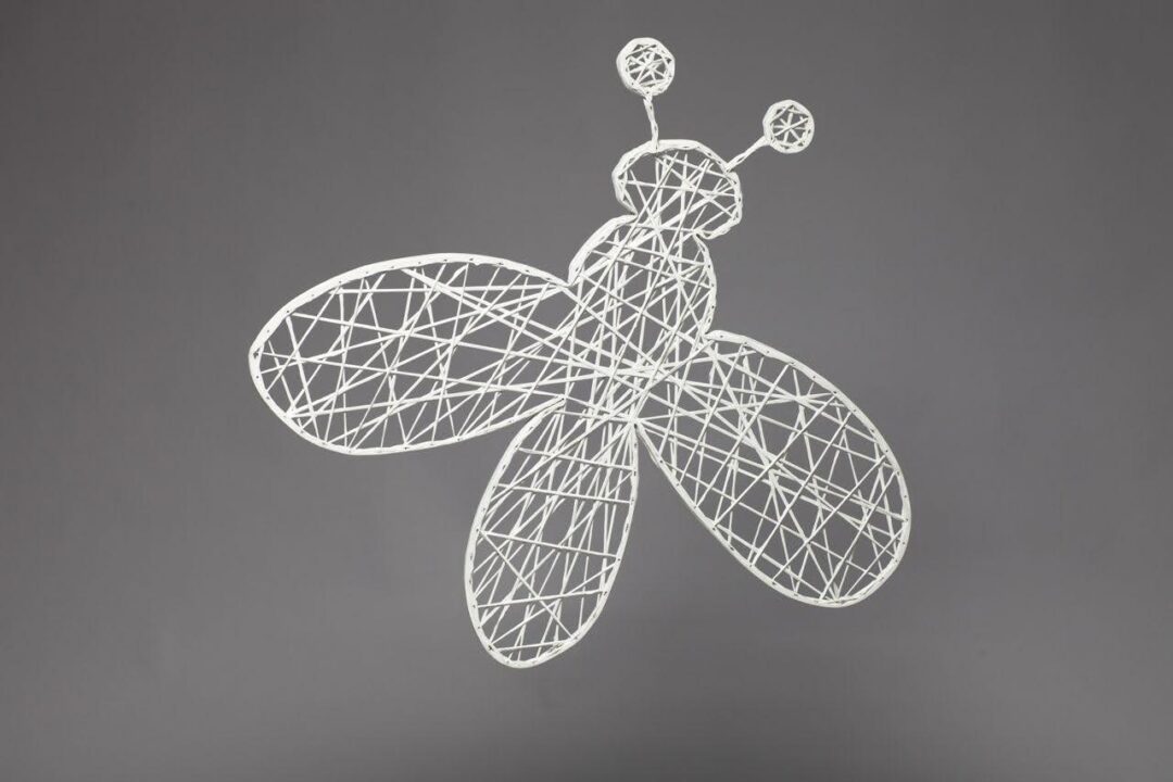 An image of a white two dimensional bee made of strings of fiberglass.