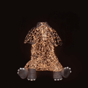 An image of a small, sitting elephant made of a wire frame, warm white mini LED Christmas lights, and fiberglass accents.
