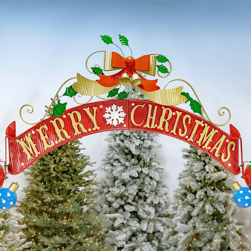 An image of a larch Christmas themed archway. The pillars are made up of stacked ornaments with an elf on each side. The top of the archway says "Merry Christmas" and has bells and holly leaves above it.