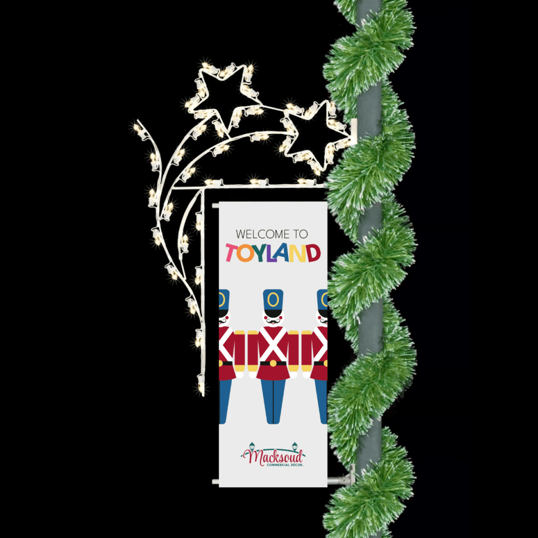 A Christmas banner surrounded by shooting stars made from white LED lights. Mounted on a pole with green pine garland.