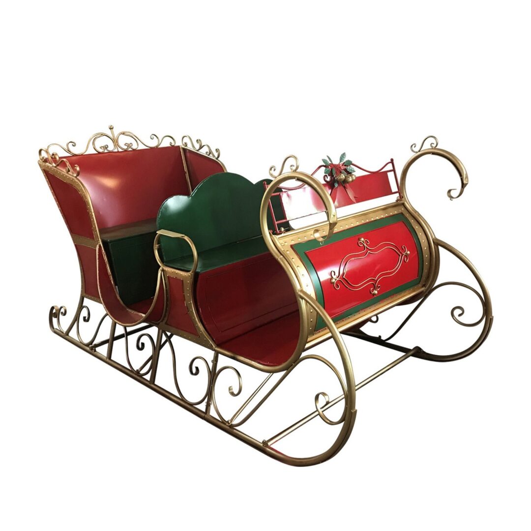 A large red iron sleigh with green seats, gold accents, and gold sleigh runners.