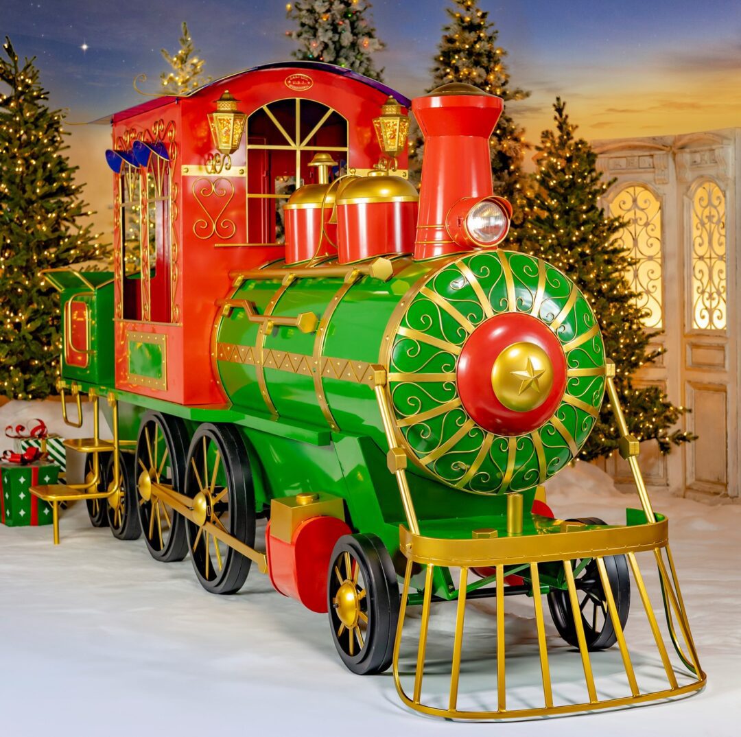 A large red and green iron Christmas train steam engine and coal tender.