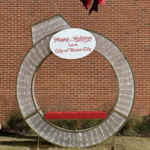 A large mesh ring with a Christmas ornament cap, and a red bench on the bottom.