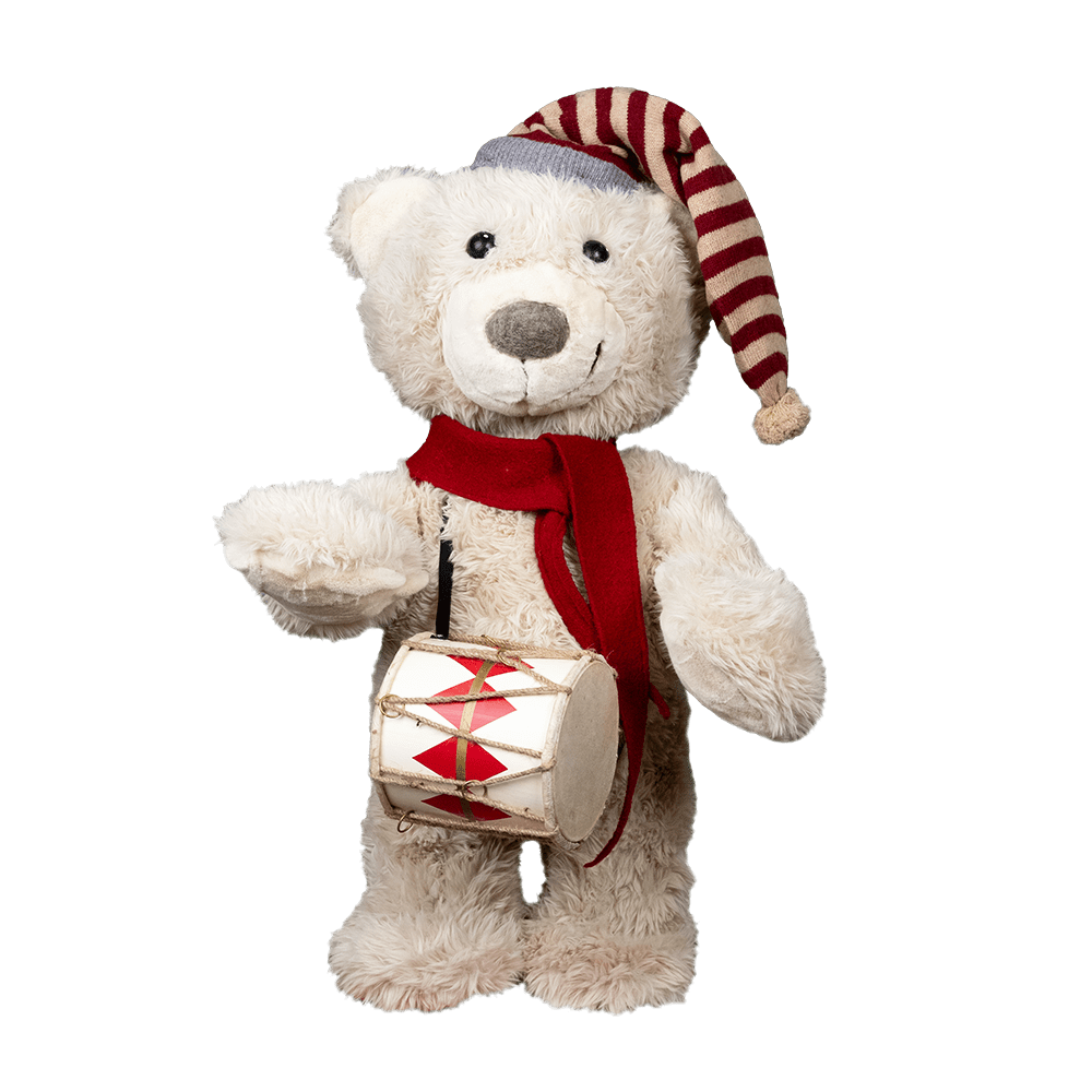 A white teddy bear wearing a red and white stripped hat and a red scarf, playing a toy drum.