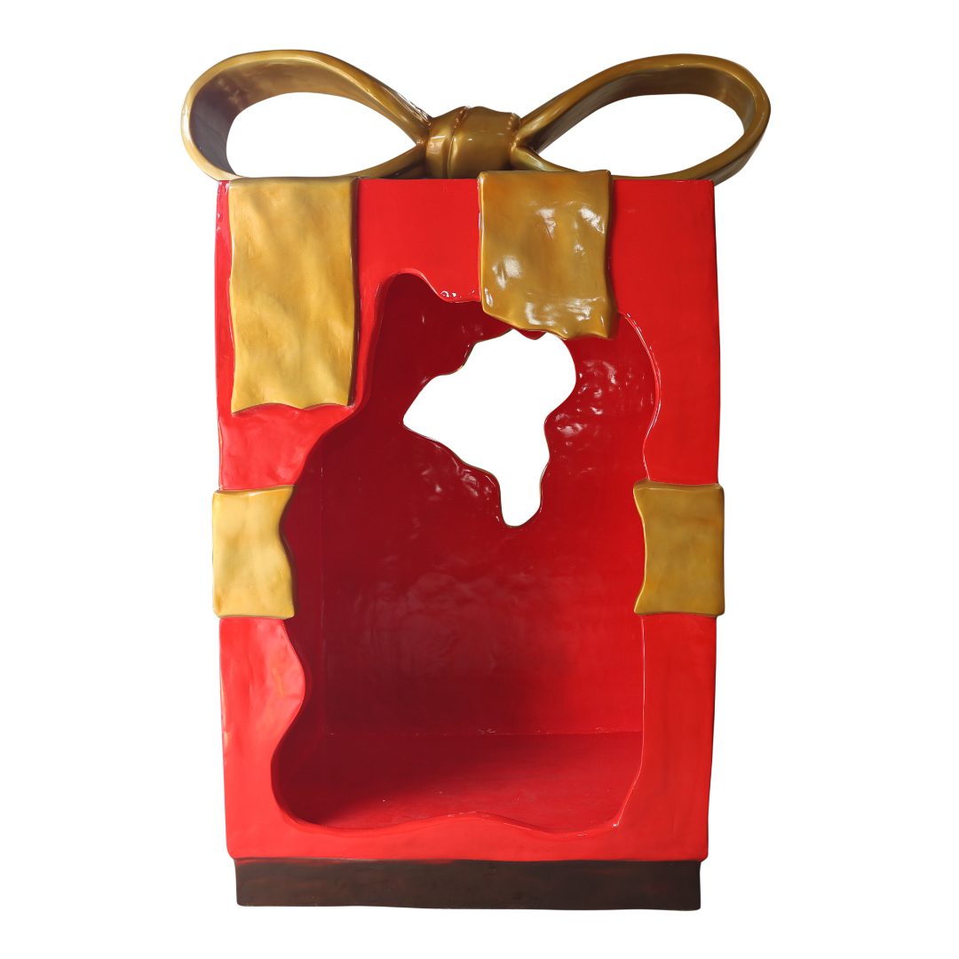 A large red Christmas parcel with a gold bow, torn open in the middle.