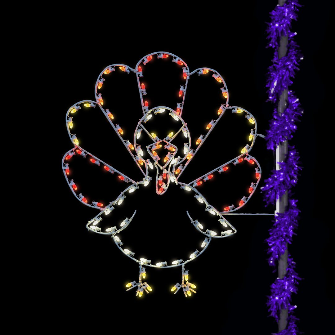A Christmas light silhouette of a forward-facing turkey, mounted to the side of a light pole wrapped with purple garland.