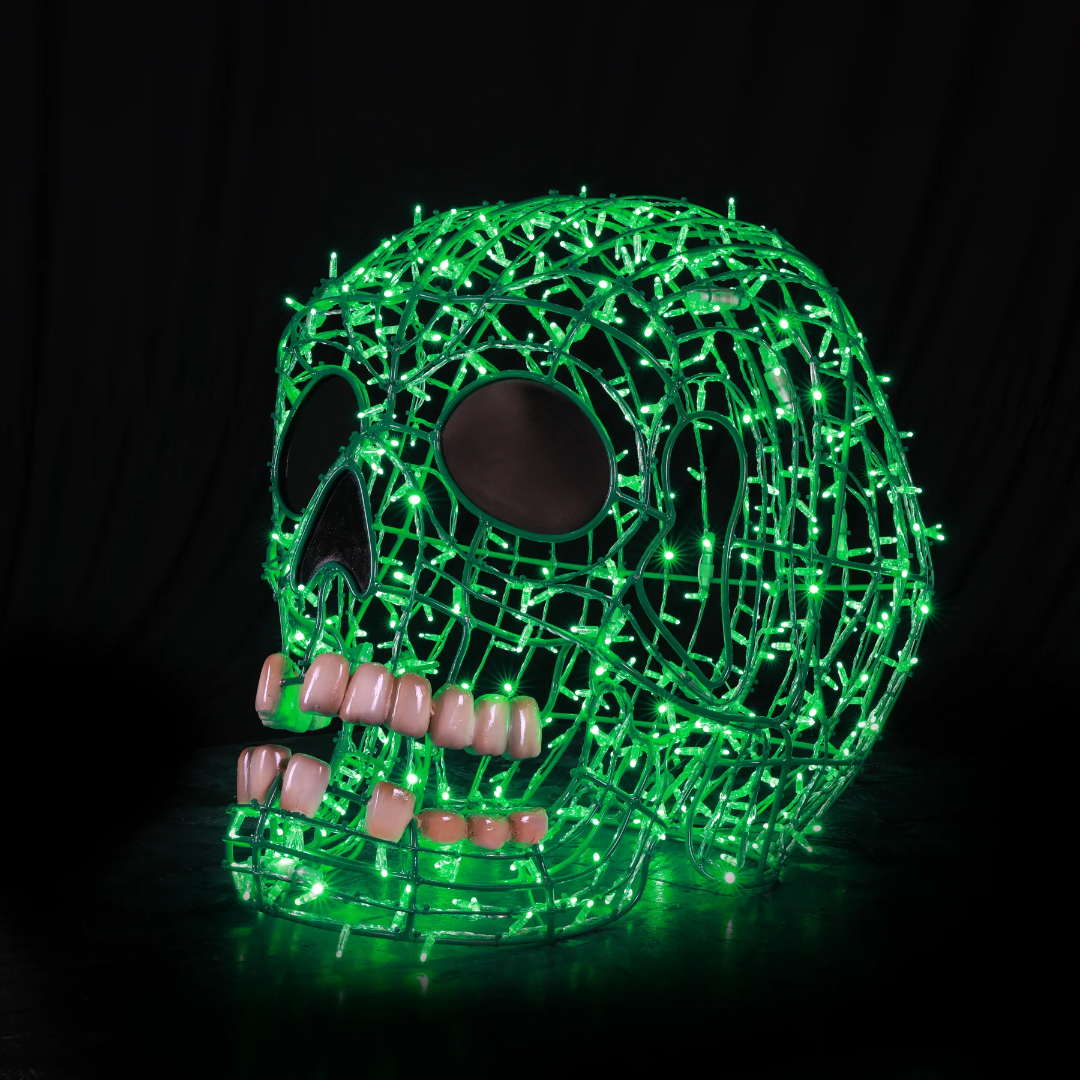 A Christmas light display of a 3D smiling human skull made from green mini LED Christmas lights.