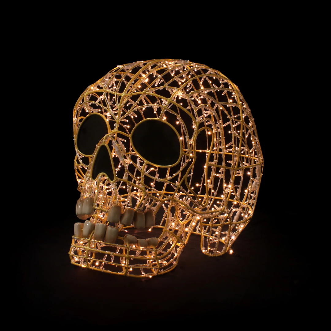 A Christmas light display of a 3D smiling human skull made from yellow mini LED Christmas lights.